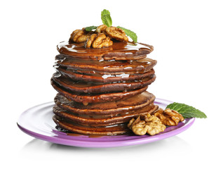 Tasty pancakes with walnut and sweet sauce on purple plate, isolated on white