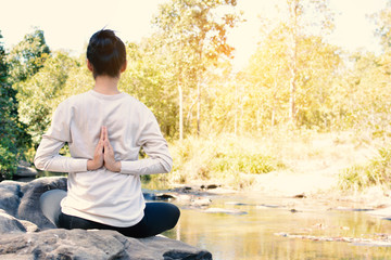 Fototapeta premium Asian women yoga in nature near waterfall relax time