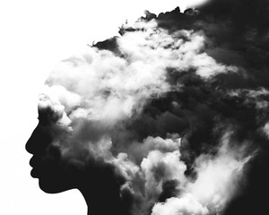 Monochrome double exposure of girl profile portrait and stormy cloudscape
