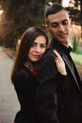 Young couple holding hands, smile and walk in the park in one au