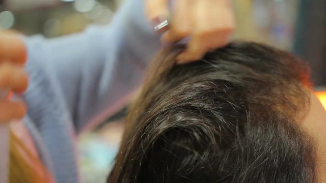 Experienced hair stylist creating beautiful hairstyle for female customer