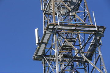 Metal frame of telecommunications tower in front of a dark blue sky