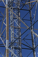 Metal frame of telecommunications tower in front of a dark blue sky