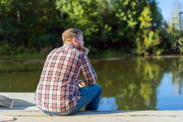 Man sitting on the dock by the lake