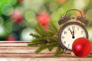 Christmas holiday background with alarm clock and tree branch on