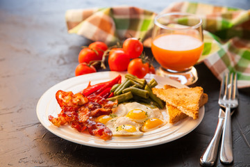 breakfast - fried eggs, haricot, a paprika and bacon in a plate, selective focus