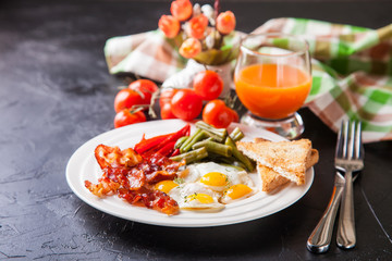 breakfast - fried eggs, haricot, a paprika and bacon in a plate, selective focus