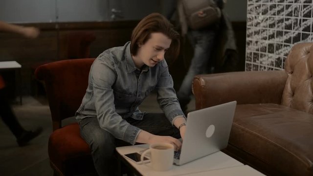 lucky handsome man working on a laptop, man typing on a laptop