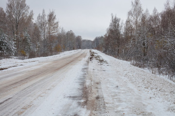 Obraz premium the snow-covered winter road in the wood