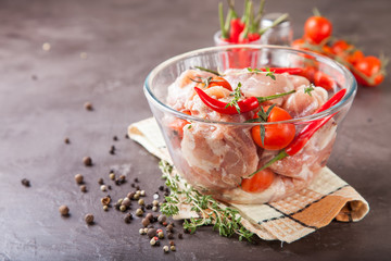 pieces of meat of chicken with tomatoes and pepper in a bowl on a table, selective focus, copy space