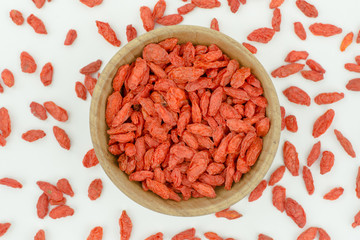 goji berries in wood bowl isolated on white background