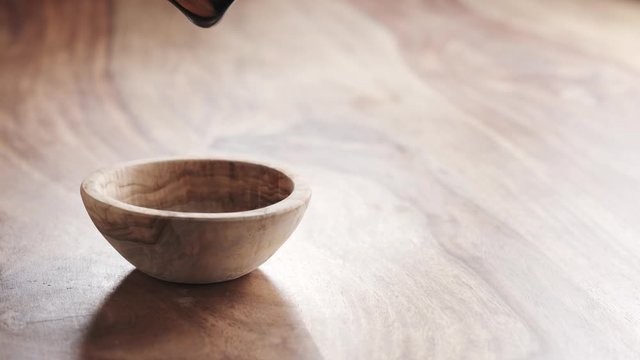 almonds falling in wood bowl on wooden table in slow motion, 180fps prores footage