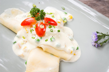 Crepes stuffed with cream cheese and chicken with white cream sauce