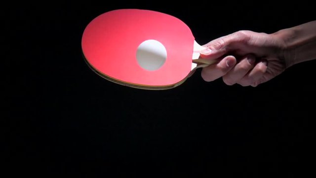 Hand holding table tennis racket and serve ping pong ball. Slow motion film clip with sport equipment.