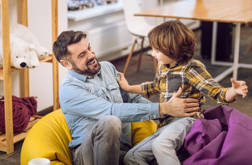 Portrait of father and his teenager son having fun