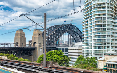 Sydney Harbour Bridge and city buildings along railway