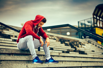 Young man resting on the stairs after running