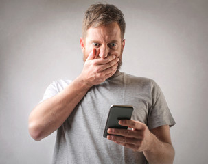 Man with phone covering his mouth