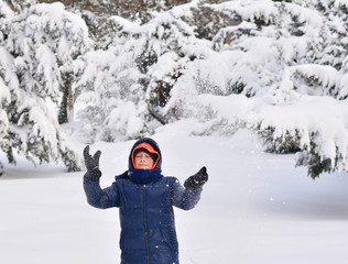 Fototapeta na wymiar The magic of winter . Child having fun, playing with snow.