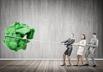 Young business people and huge paper ball as symbol of creativity