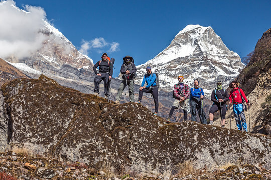 Diverse Group Of Hikers Staying On Rock In Himalaya Mountains