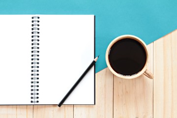 Still life, business, office supplies or education concept : Top view of working desk with blank notebook with pencil and coffee cup on wooden background