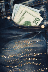 Money sticks out of the pocket of his jeans with rhinestones