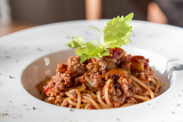 spaghetti tomato sauce with beef and pork in white deep plate