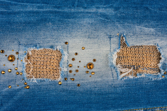 Texture of denim fabric with gold threads, inlaid rhinestones.