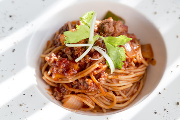 spaghetti tomato sauce with beef and pork in white deep plate