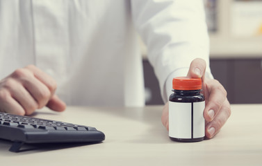 Pharmacist holding bottle with drugs
