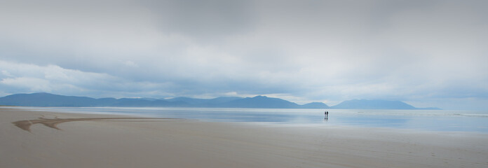 Two figures on vast secluded Inch Beach, at Dingle Peninsula, Co. Kerry, Ireland