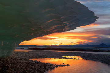 Large ice-visor and the sunset on the horizon. Moma River. Yakutia. Russia.