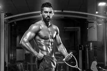 Fototapeta na wymiar Muscular man working out in gym doing exercises, strong male naked torso abs