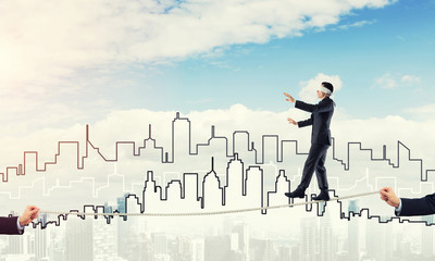 Business concept of risk support and assistance with man balancing on rope