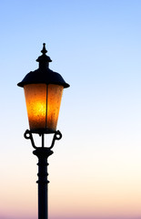 Fototapeta na wymiar Old lamp in sunset