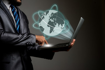 Businessman holding laptop Global erupt from screen, Connecting