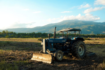 soil tractor in the farmland with beautiful mountain behind