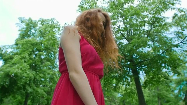 attractive girl with red hair enjoying nature