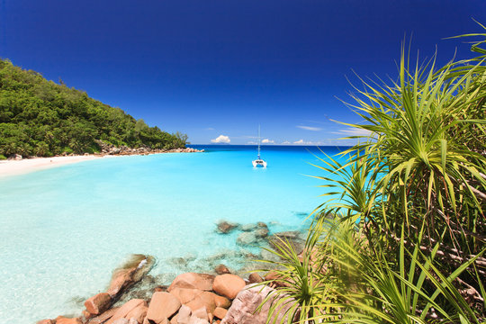 Seychellen Traumstrand mit Boot in Bucht und t&uuml;rkisem Wasser