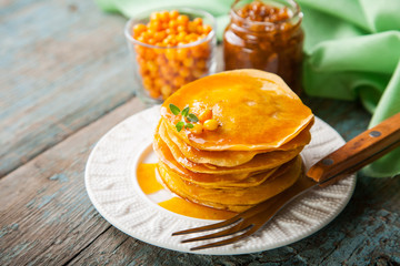 pumpkin pancakes with syrup in a plate on a table, selective focus, copy space