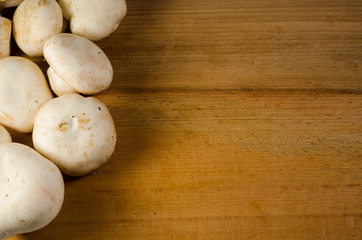 White champignon mushrooms on a wooden table