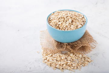 Oat flakes in a bowl on a table, selective focus, copy space
