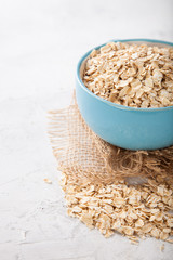 Oat flakes in a bowl on a table, selective focus, copy space