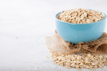 Oat flakes in a bowl on a table, selective focus, copy space