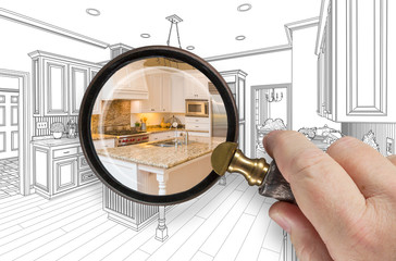 Hand Holding Magnifying Glass Revealing Custom Kitchen Design Drawing and Photo Combination.
