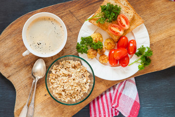 breakfast - muesli, coffee, a toast and tomatoes on a table, the top view, selective focus, copy space