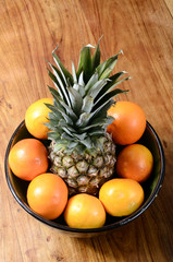 Pineapple and oranges in a bowl