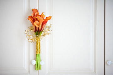 calla lilies on the background of a wooden cabinet