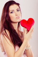 Beautiful woman holds red heart